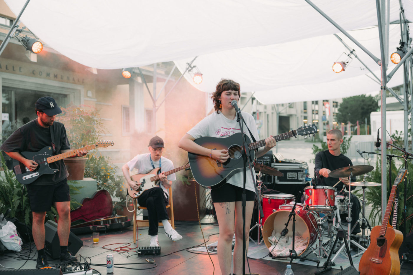On voit un groupe de musique sur une scène. La chanteuse clair my flair est devant à droite et on aperçoit les trois autres musiciens derrière autour d'elle.