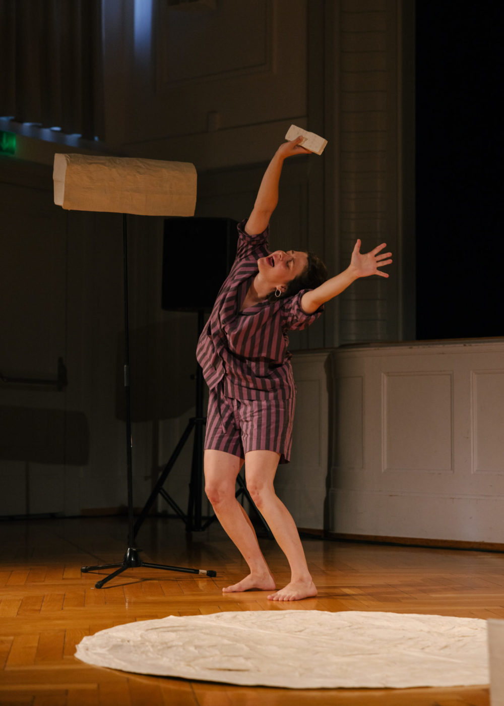 L'artiste Annina Polivka se tient sur scène debout, les mains en l'air, imaginant un vent d'air la rafraichir.