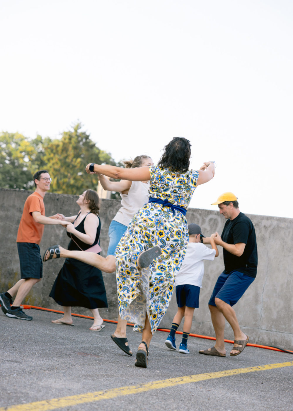 On voit des couples de personne danser la valse. Au premier plan, on voit une femme de dos avec sa partenaire qui a juste le bout d'un pied par terre. Elle semble élevée dans les airs.