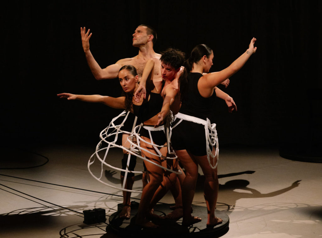 Les quatre danseureuses sont sur une petite plateforme ronde noire et ils forment un cercle. Leurs corps sortent du cercle. On le voit à travers les bras qui se lèvent et les regards dans des directions différentes. Les costumes de valse sont de couleur noire mais d'autres parties sont blanches.